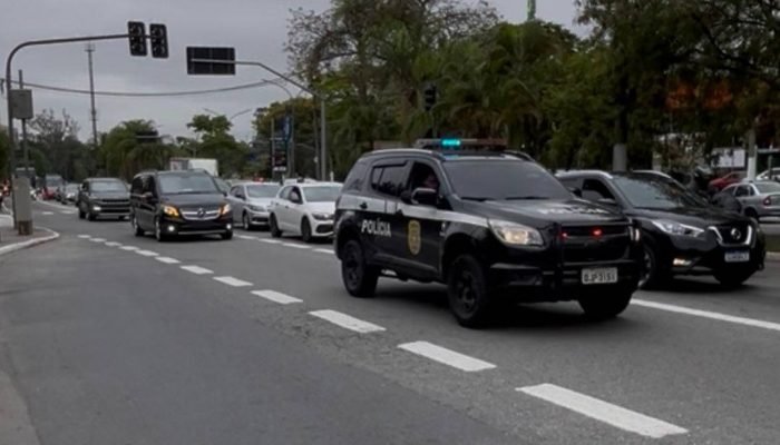 Carro da polícia civil escolta veículo sem placas em combaio em direção ao autódromo de Inte...
